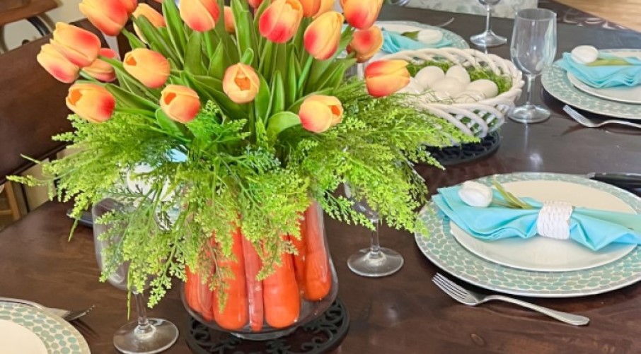Spring centerpiece of faux tulips and a carrot-filled vase